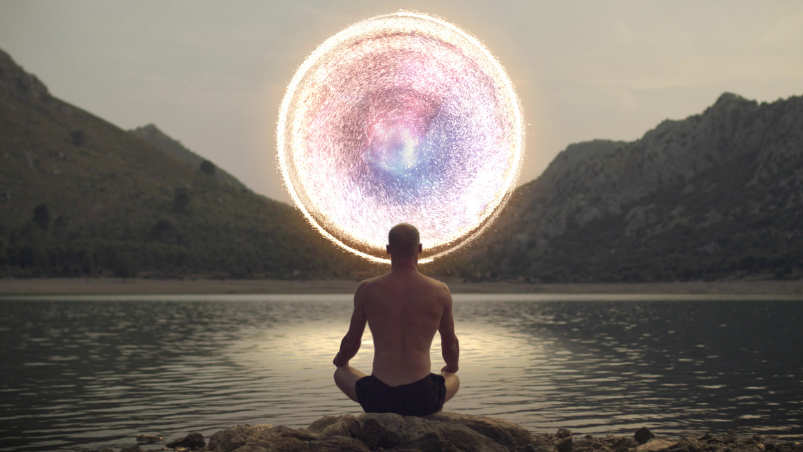 Meditating man opening portal to cosmic energy.